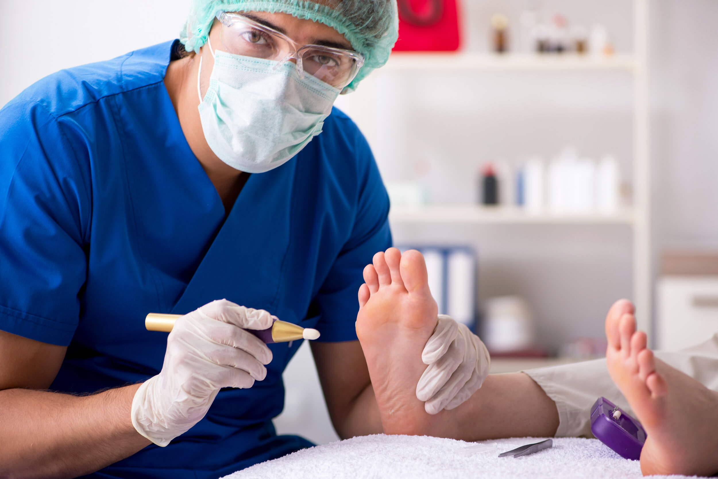 Podiatrist treating feet during procedure