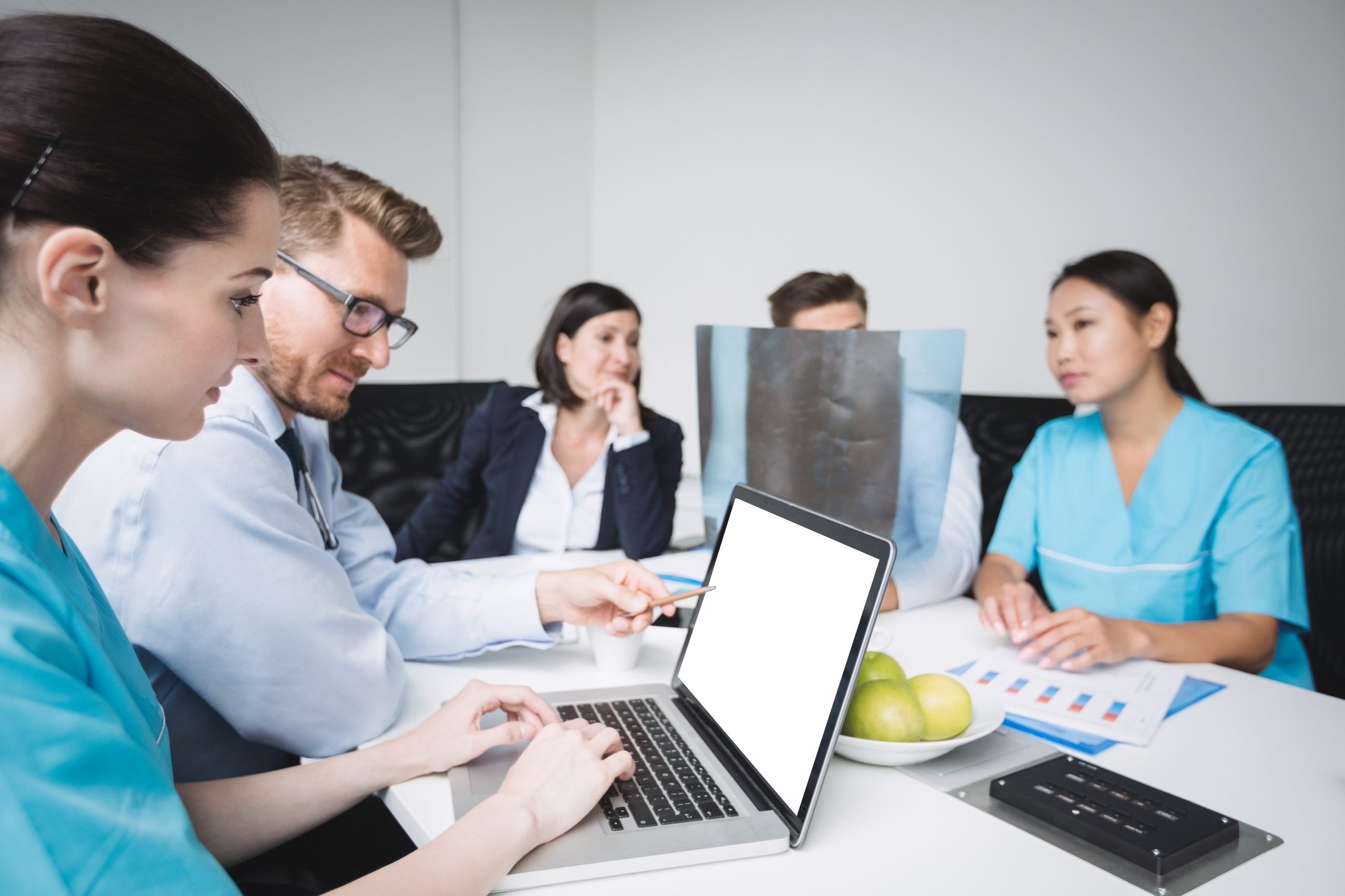 Doctors discussing over laptop in meeting at conference room